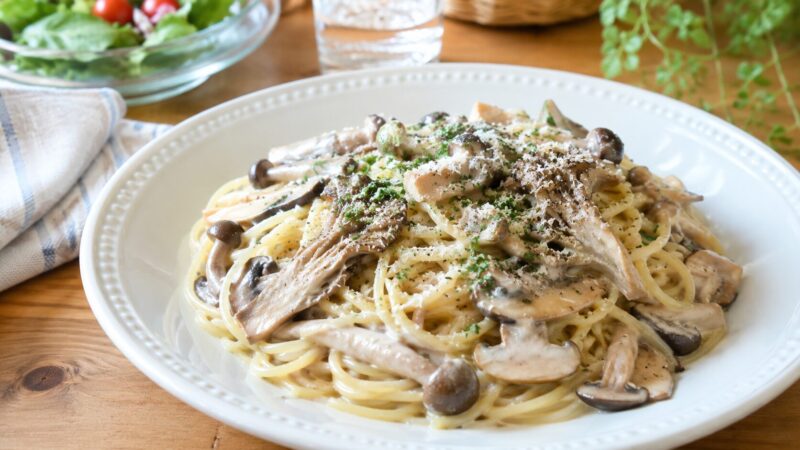 しめじとまいたけを使ったきのこクリームパスタを白い皿に盛り付けた完成写真